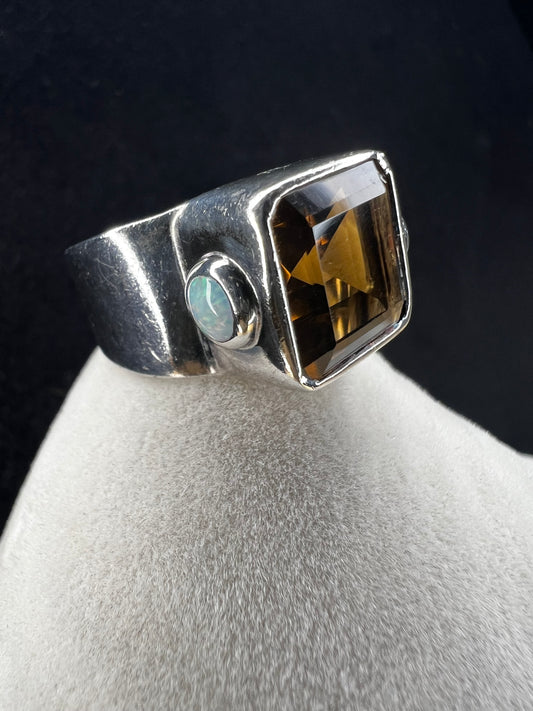 This expertly crafted vintage ring showcases a large, vibrant citrine centerpiece flanked by two luminous opals, all set in high-quality sterling silver. The hallmark of the maker (CM) is stamped on the inside.