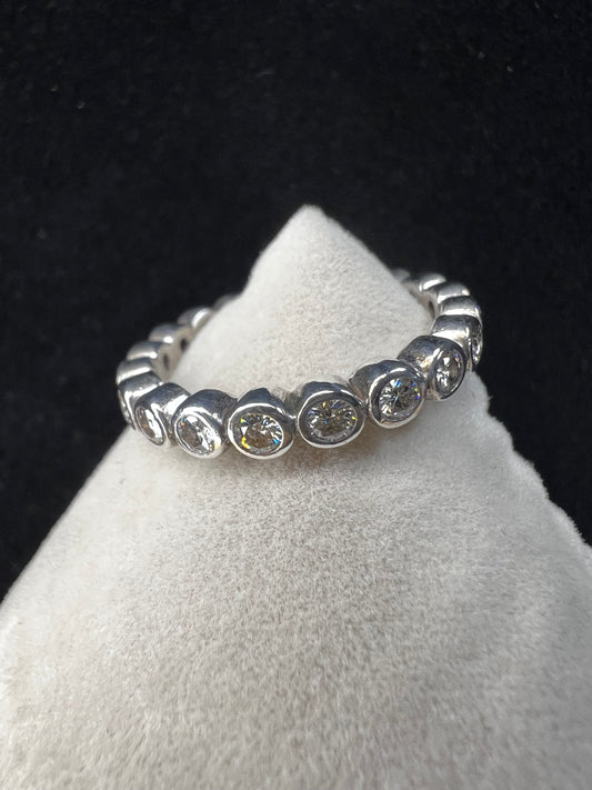This sterling silver eternity band ring is designed with moissanite stones encircling the entire band, creating a beautiful and radiant look. Signed C&C.
