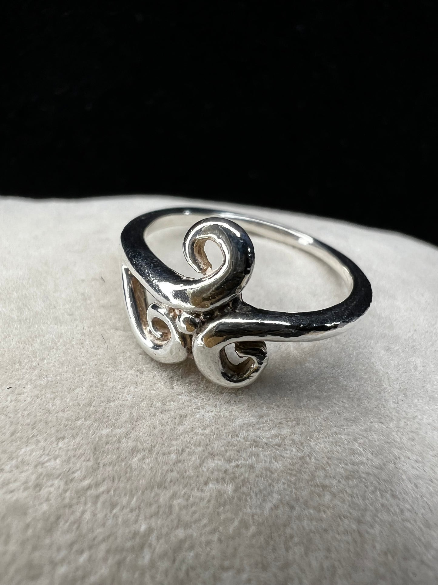 This is a simple but elegant sterling silver ring. The design features swirls that are reminiscent of ocean waves crashing on a beach.