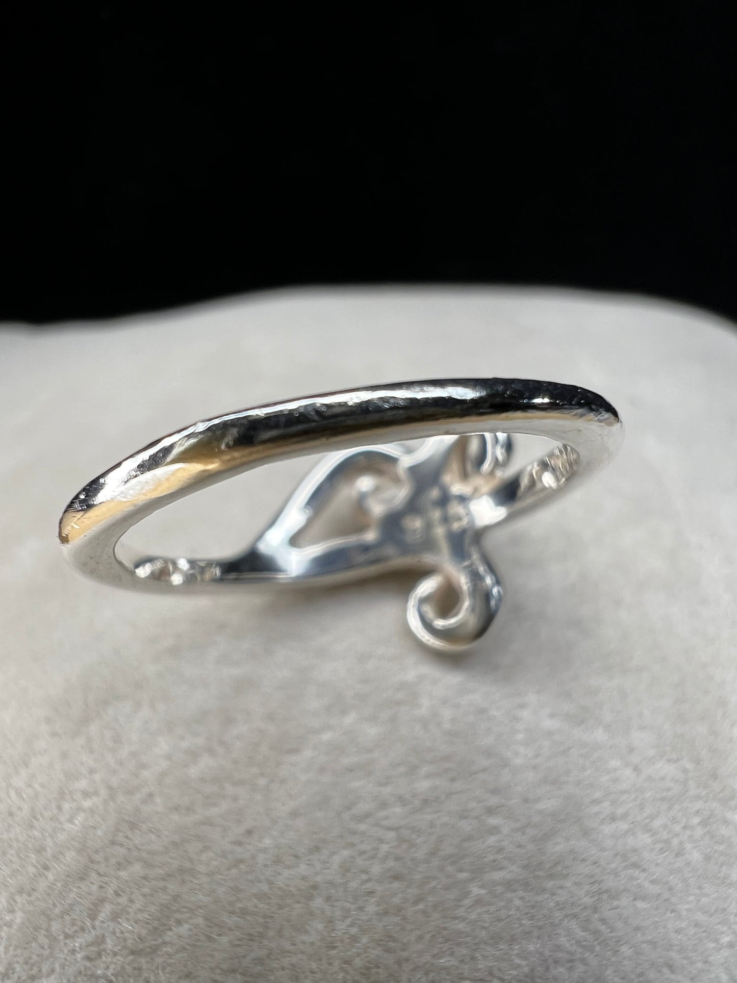 This is a simple but elegant sterling silver ring. The design features swirls that are reminiscent of ocean waves crashing on a beach.