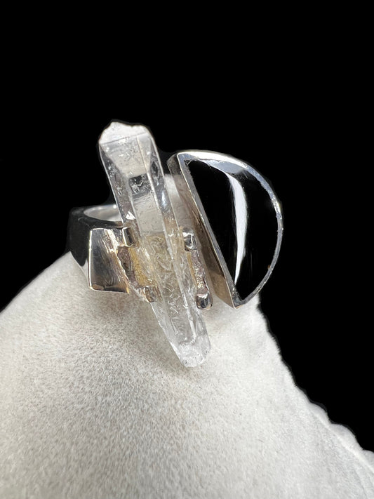 This sterling silver ring features a striking combination of black enamel and a natural crystal specimen. Its moderate size ensures it stands out without overwhelming, making it an ideal complement to any outfit.