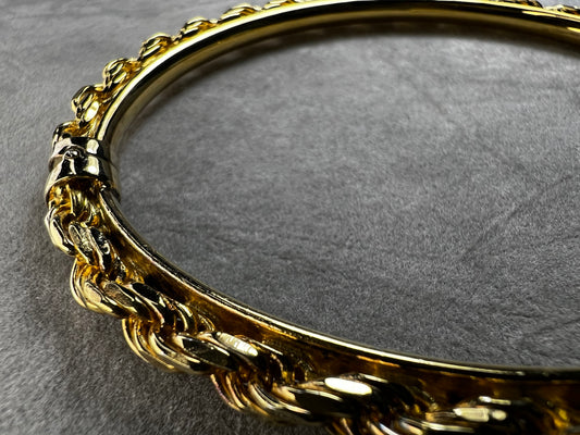 Crafted from sterling silver with a gold overlay, this rope chain bangle bracelet offers both style and comfort. Its beautiful design is complemented by a smooth inner plate for a comfortable fit.