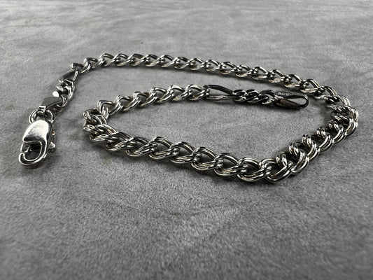 Expertly crafted in Italy, this sterling silver bracelet showcases a refined dual link design. It features a 4.5 mm double link chain complemented by a distinctive 1/2" figaro link segment at each end, creating a sophisticated contrast. This piece offers a subtle yet unique aesthetic.