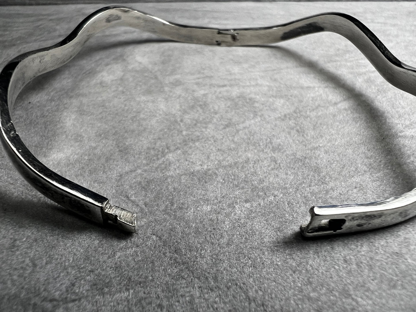 This vintage Taxco sterling silver bracelet features a distinctive wavy design and is marked TM-37, showcasing authentic craftsmanship from Mexico. Its timeless style makes it a versatile accessory for everyday wear or special occasions.
