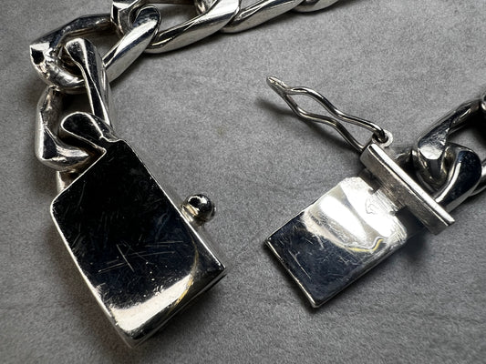 This vintage Cuban link bracelet is a sturdy and stylish accessory crafted from solid sterling silver. Measuring 12mm wide, it features a secure locking clasp designed for durability and everyday wear. Made in Mexico.