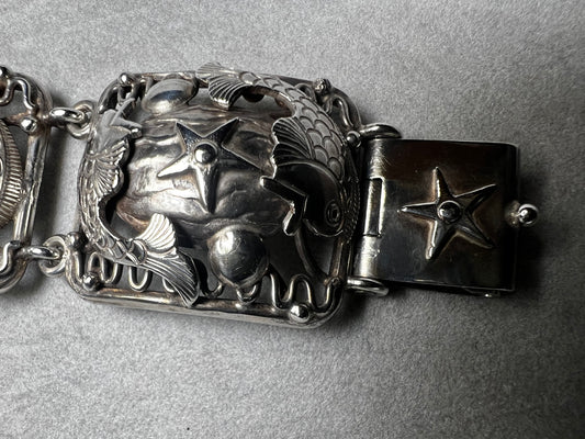 This vintage Denmark sterling silver bracelet, featuring charming fish and star motifs, is a rare find. Its unique design adds a touch of timeless elegance to any outfit, making it a special piece to treasure.