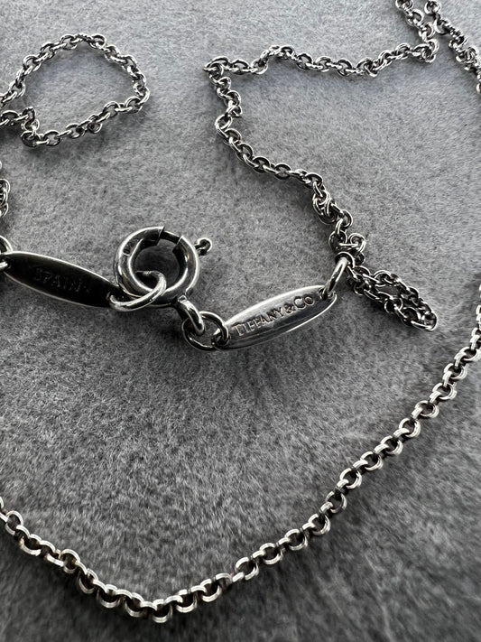 This vintage sterling silver chain by Elsa Peretti for Tiffany & Co. offers a rare opportunity to acquire a distinguished piece of jewelry history. Its petite design exemplifies refined craftsmanship and timeless elegance. Made in Spain.