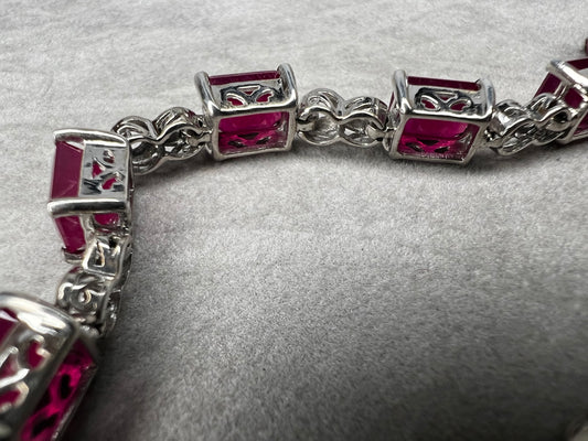 This bracelet is crafted from sterling silver and set with stunning lab-created rubies. It's a piece that's sure to enhance any outfit.