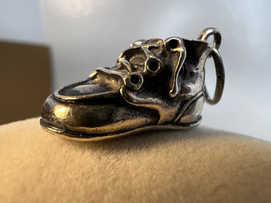 Indulge in some cuteness with this vintage sterling silver charm. Expertly crafted as a miniature baby shoe, this piece is perfect for a new parent or anyone who enjoys a touch of nostalgia.