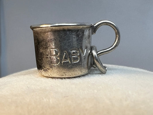 Crafted with charming detail, this vintage sterling silver charm is designed as a baby cup. Perfect for a new parent or anyone who enjoys a reminder of their favorite little one.