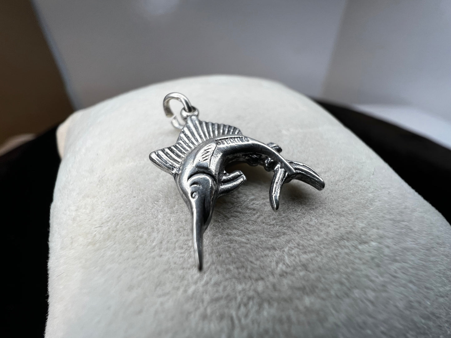 This sterling silver charm (or pendant) is expertly crafted as a swordfish, a symbol of strength and determination. The intricate design captures the essence of this sleek sea creature.