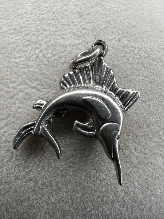 This sterling silver charm (or pendant) is expertly crafted as a swordfish, a symbol of strength and determination. The intricate design captures the essence of this sleek sea creature.