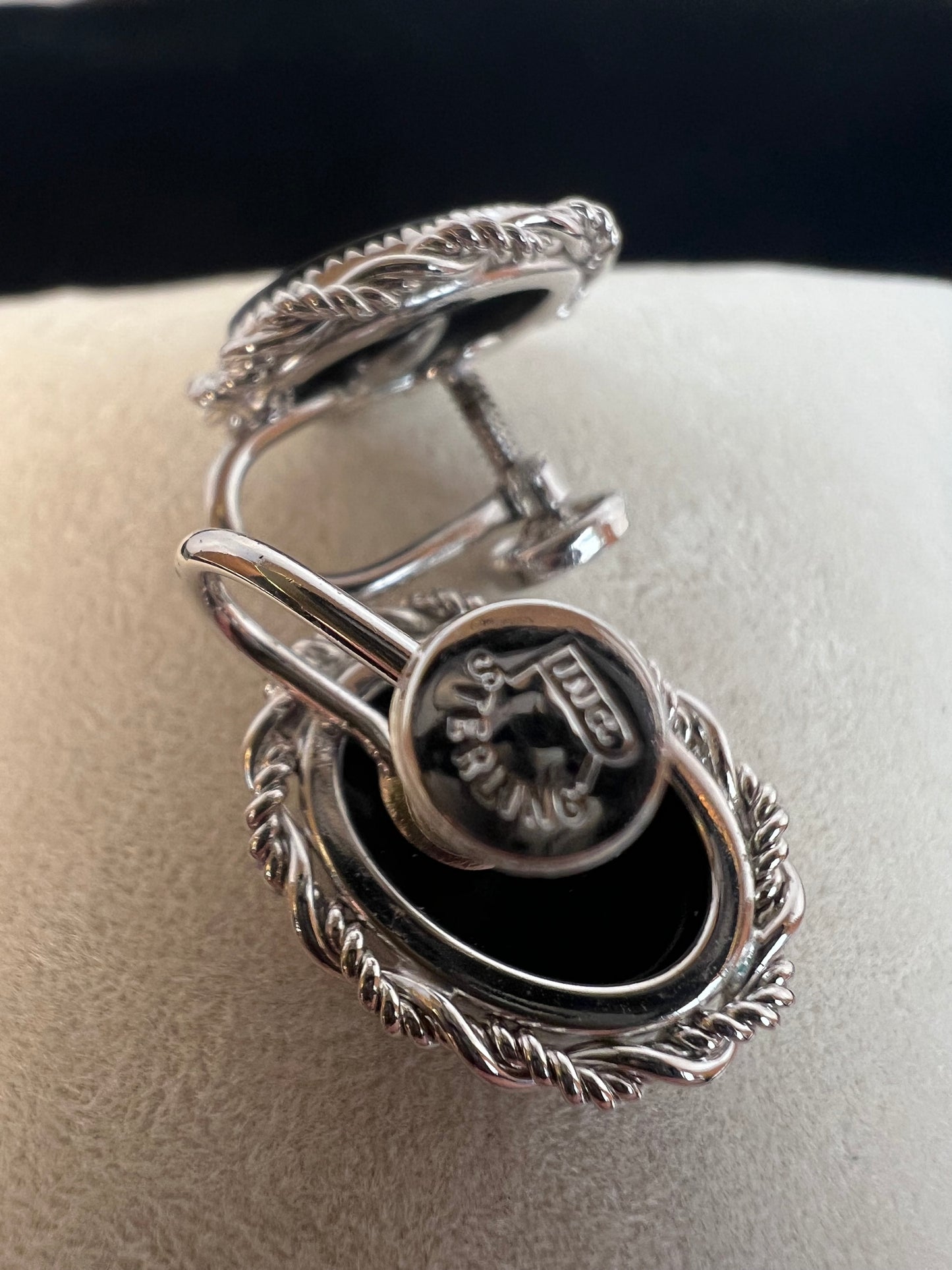 This brooch and earrings set will add sophistication to any outfit. Crafted from fine sterling silver with intricate detail work, the brooch features a flower whose center is an onyx stone. The earrings, which have screw-back closures, are adorned with matching onyx stones.