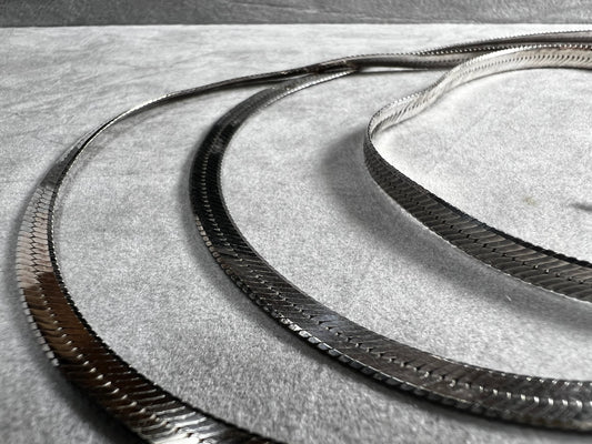 This sterling silver herringbone necklace combines length and strength with refined elegance. Ideal for those seeking a longer chain, it provides a graceful drape while offering the durability needed to support larger pendants with confidence and style.