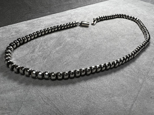 This vintage necklace from Taxco features a sterling silver chain accented with authentic Navajo pearl beads, showcasing traditional craftsmanship. Its timeless design makes it a distinguished addition to any Taxco collection, offering both cultural significance and enduring style.