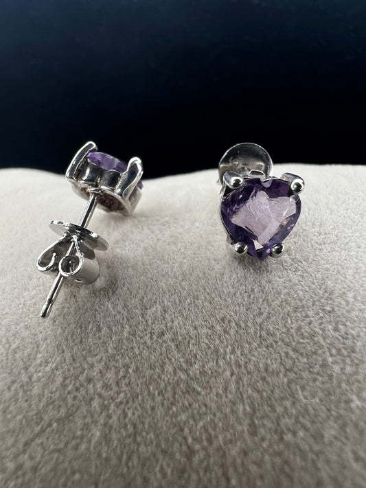 These sterling silver earrings feature heart-shaped amethyst stones, expertly cut to showcase their natural beauty. The rich purple hues of the amethyst add a touch of elegance. Perfect for adding a subtle yet sophisticated accent to any outfit.
