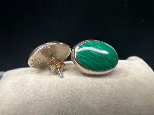These vintage Mexican earrings showcase genuine malachite stones expertly set in sterling silver. Each piece is hallmarked, reflecting authentic craftsmanship and quality.