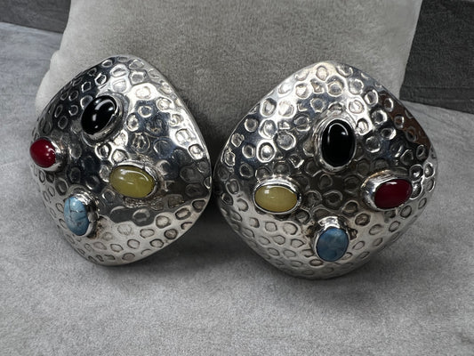 These vintage Taxco sterling silver clip-on earrings feature authentic hallmarks and vibrant natural stone cabochons. Expertly crafted, they combine timeless Mexican silver artistry with bold, eye-catching colors, making them a distinguished accessory for collectors and connoisseurs of fine vintage jewelry.