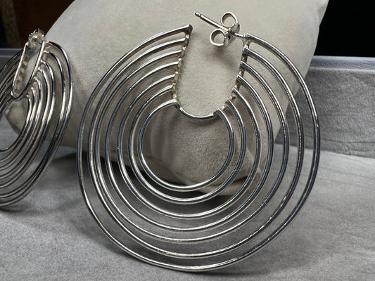 These sterling silver hoop earrings feature seven intricately crafted loops on each hoop, combining elegance with a distinctive design.