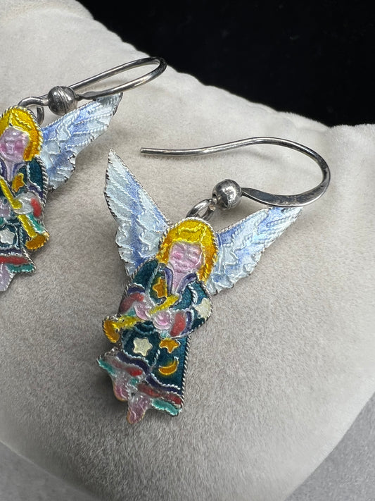 These sterling silver enameled angel earrings combine expert craftsmanship with delicate design. Perfect for those seeking a meaningful accessory, these earrings offer both elegance and a subtle symbol of protection and grace.