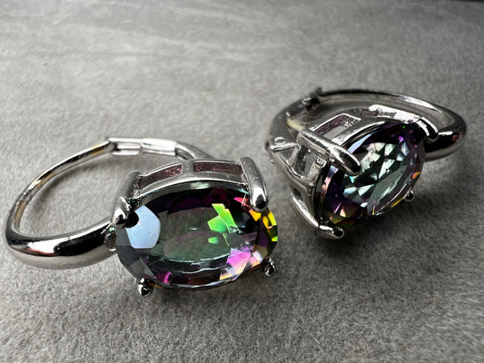 Elevate your everyday elegance with these stunning sterling silver mystic topaz earrings. Each piece showcases a radiant lab-created mystic topaz stone measuring 10 mm x 8 mm, displaying mesmerizing rainbow hues that catch the light beautifully. Crafted from genuine sterling silver, these earrings offer a perfect balance of sophistication and eye-catching sparkle.