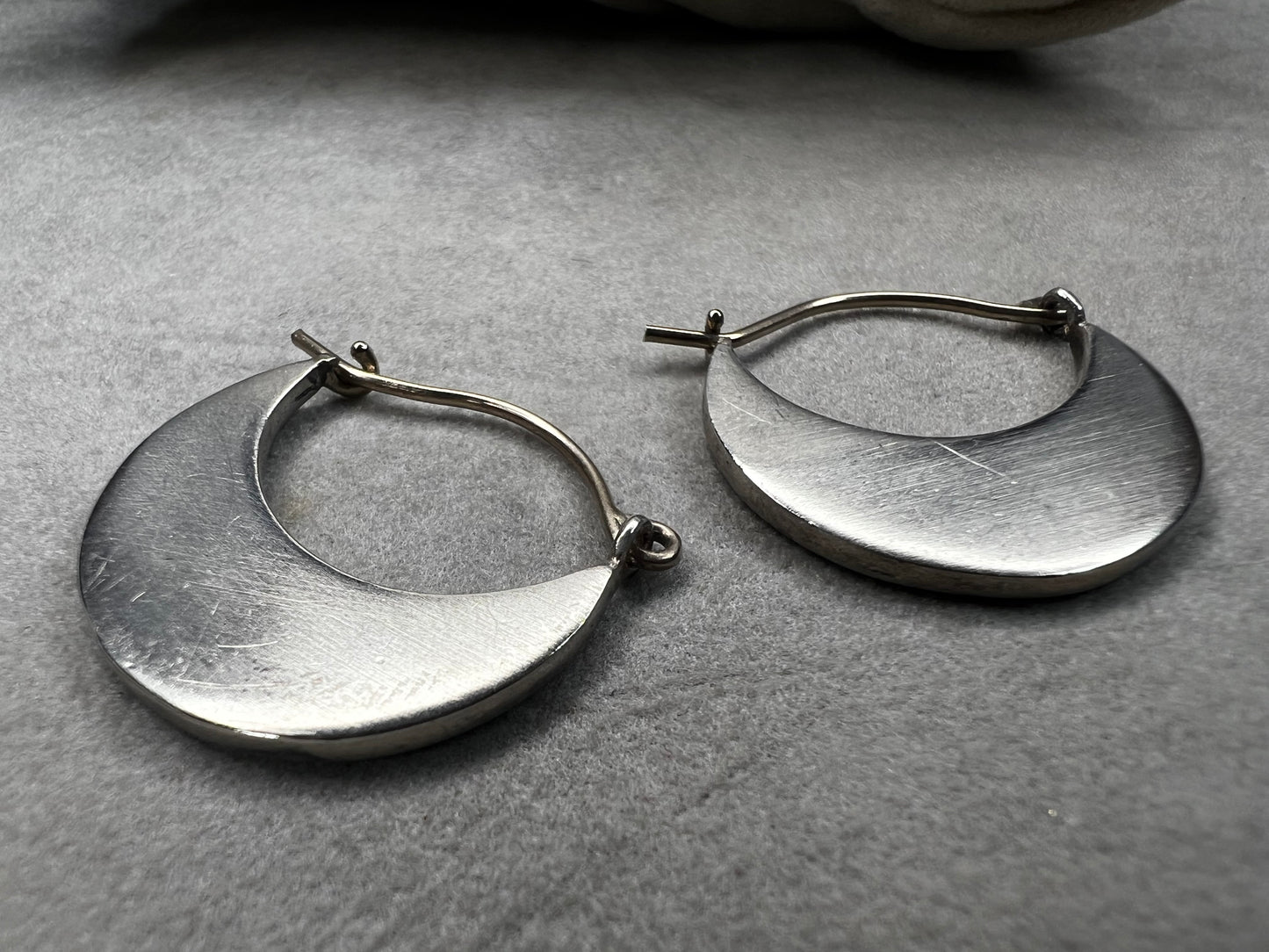 These sterling silver half moon earrings feature a brushed finish on the bottom half, paired with gold overlays on the top hooks. Combining silver and gold tones, they offer a modern, versatile style that complements everyday wear while adding an elegant touch.