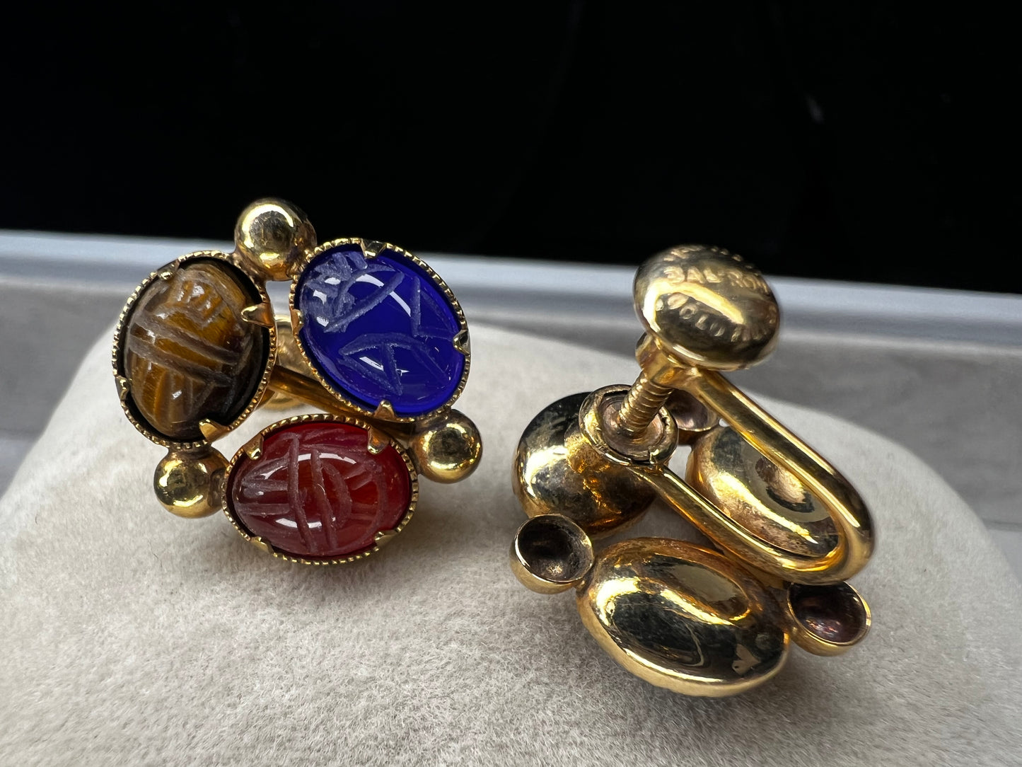 These Bal Ron gold-filled earrings feature three natural stone scarabs on each piece. Designed as screw-back earrings, they offer a unique, comfortable option for those without pierced ears. The combination of natural stones adds a subtle yet distinctive mix of colors, making these earrings an ideal choice for anyone seeking both elegance and individuality.
