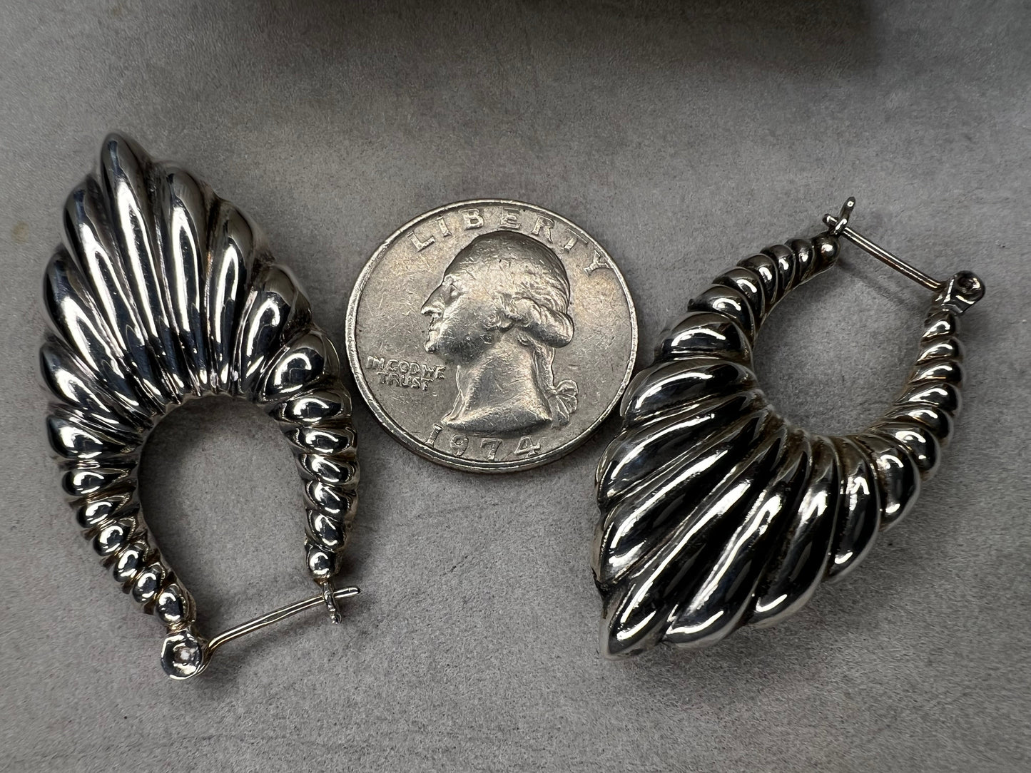 These vintage sterling silver scalloped shrimp hoop earrings are a distinctive accessory that complements any vintage-inspired ensemble. Ideal for collectors and enthusiasts seeking authentic vintage charm.