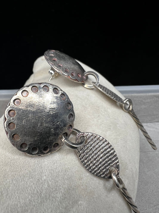 These sterling silver dangle earrings feature a distinctive 3-inch length and are signed by the designer, ensuring authenticity and exclusivity. Their elegant design complements both casual and formal attire.