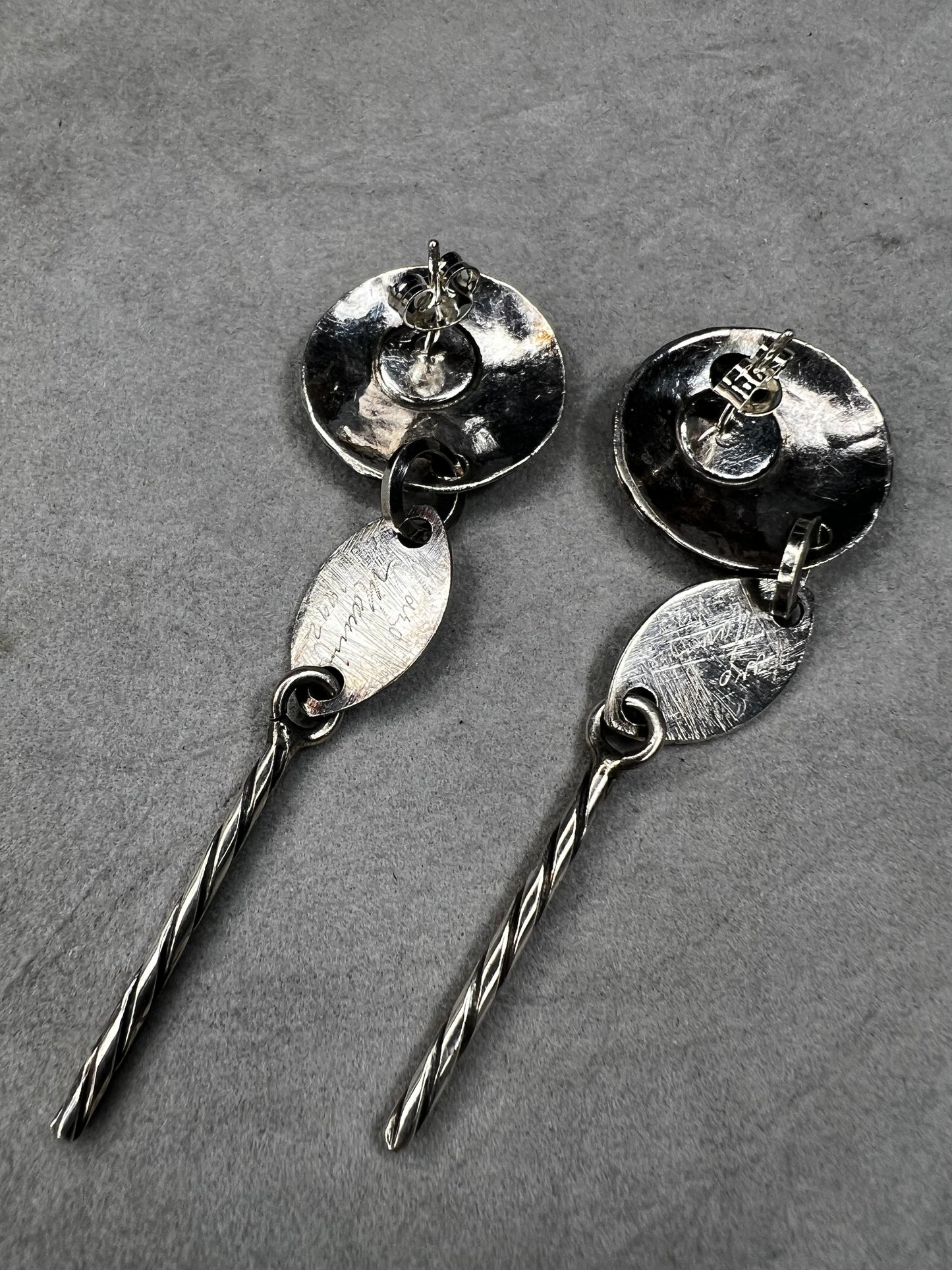 These sterling silver dangle earrings feature a distinctive 3-inch length and are signed by the designer, ensuring authenticity and exclusivity. Their elegant design complements both casual and formal attire.