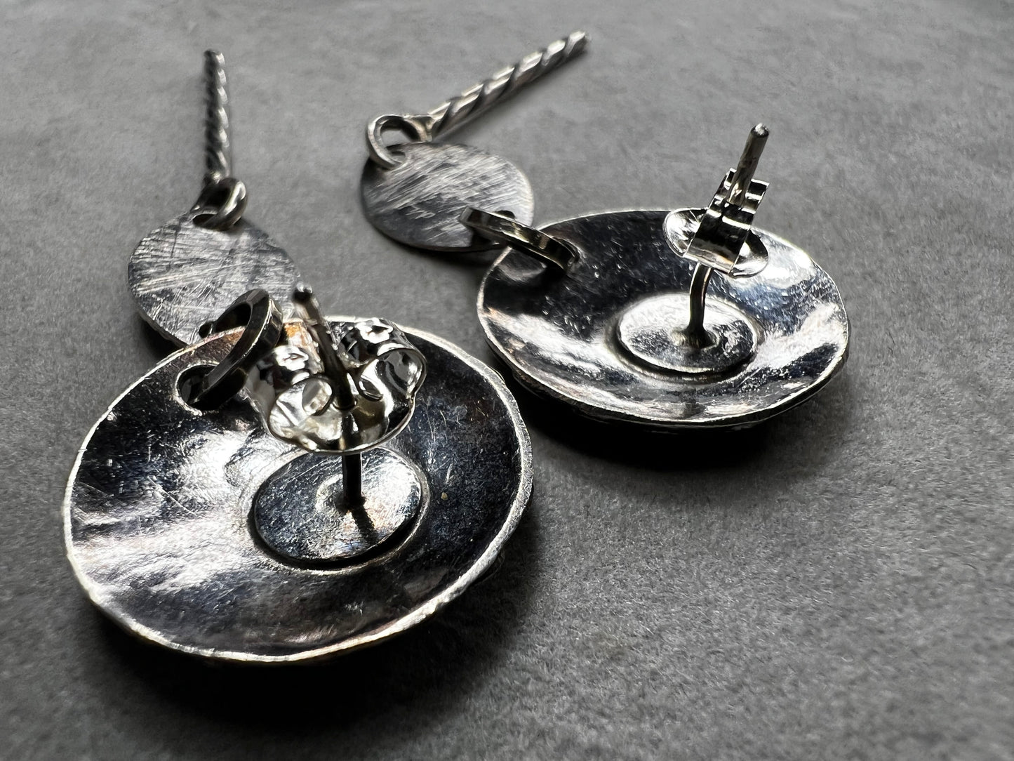 These sterling silver dangle earrings feature a distinctive 3-inch length and are signed by the designer, ensuring authenticity and exclusivity. Their elegant design complements both casual and formal attire.