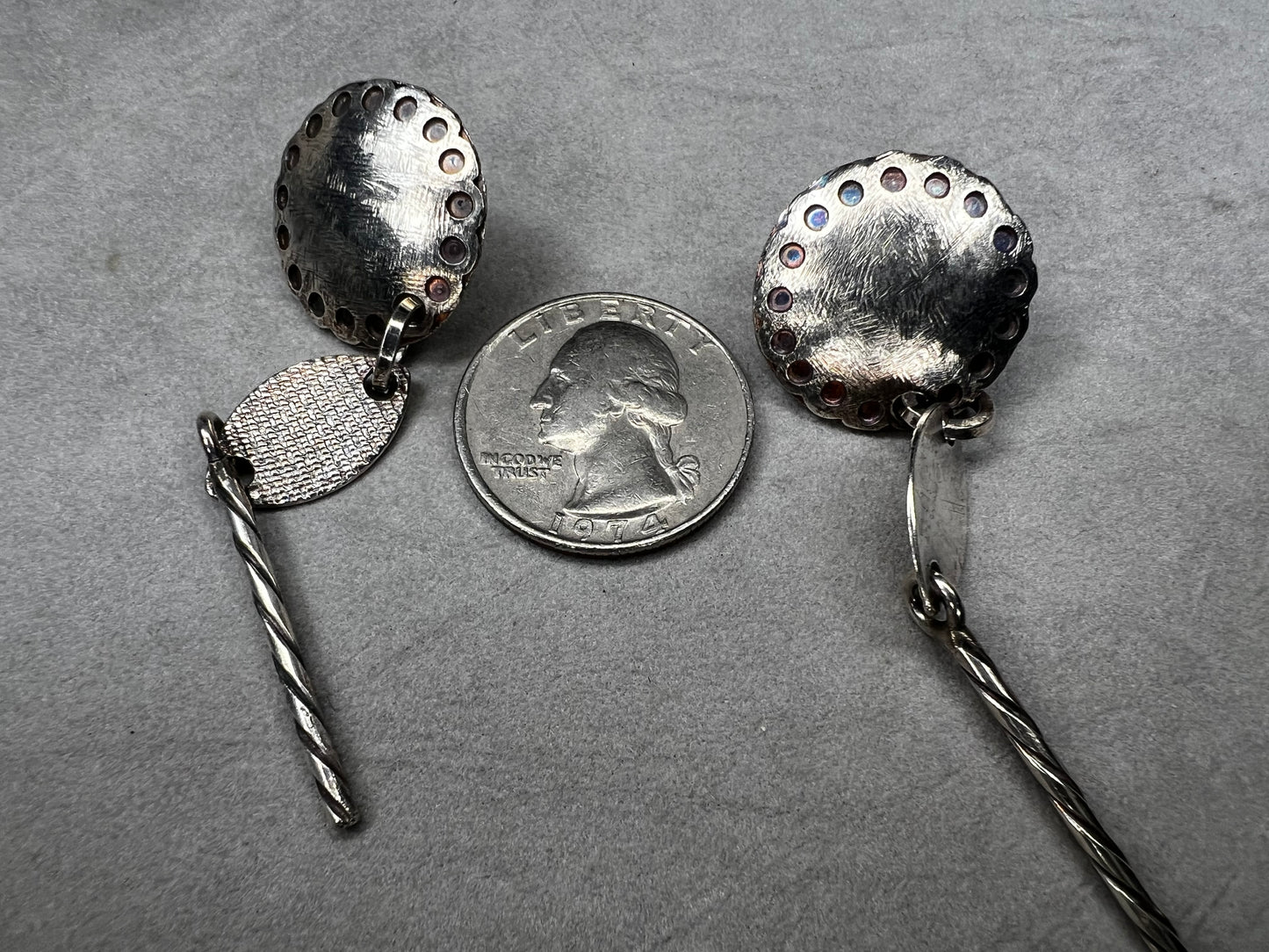 These sterling silver dangle earrings feature a distinctive 3-inch length and are signed by the designer, ensuring authenticity and exclusivity. Their elegant design complements both casual and formal attire.