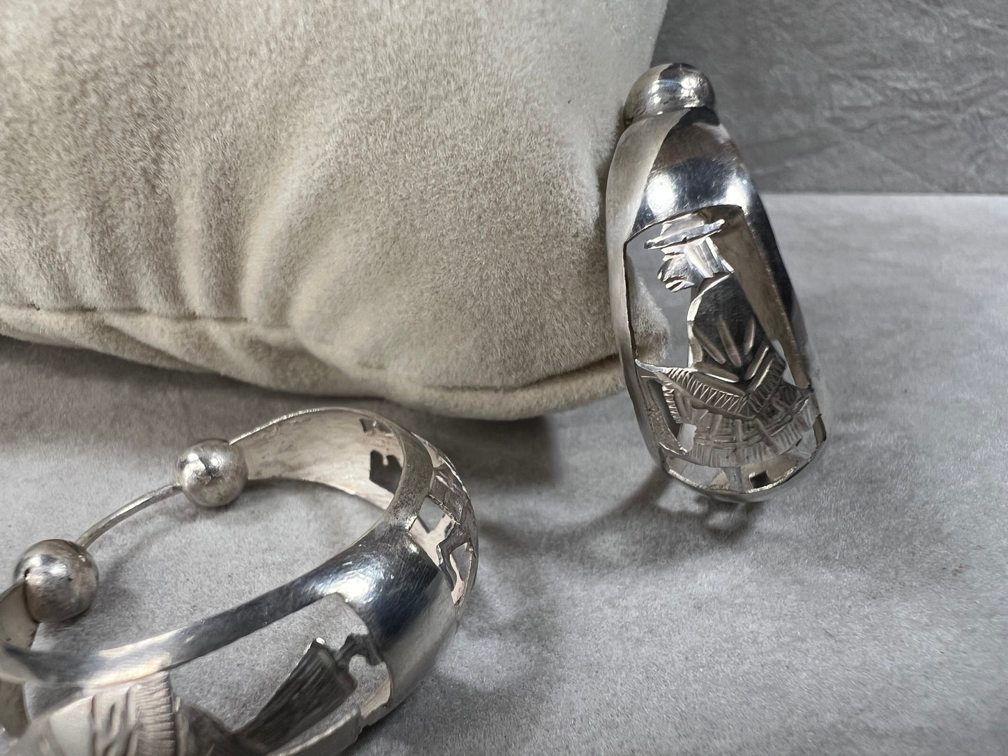 These vintage sterling silver hoop earrings showcase intricate cut-out silhouettes, blending classic design with artistic detail. Perfect for adding a subtle yet distinctive touch to any outfit.