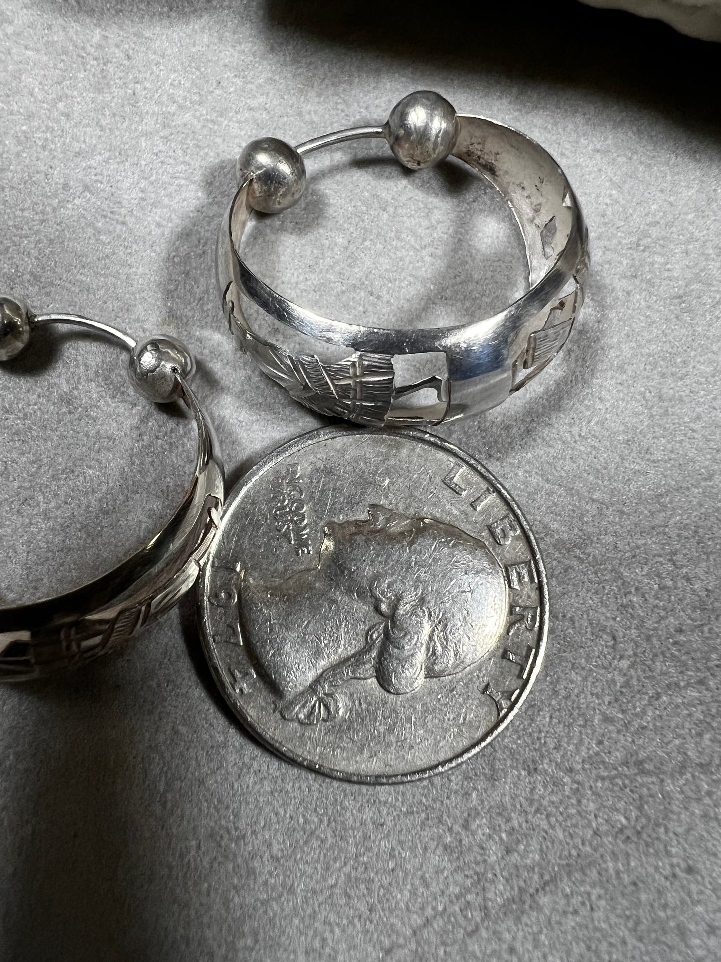 These vintage sterling silver hoop earrings showcase intricate cut-out silhouettes, blending classic design with artistic detail. Perfect for adding a subtle yet distinctive touch to any outfit.