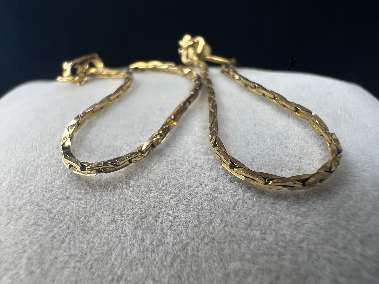 Crafted from 14k gold filled metal, these chain loop earrings feature permanently attached backs for a secure fit. The post passes through the ear, and the back loops around to close, combining elegant design with reliable functionality.