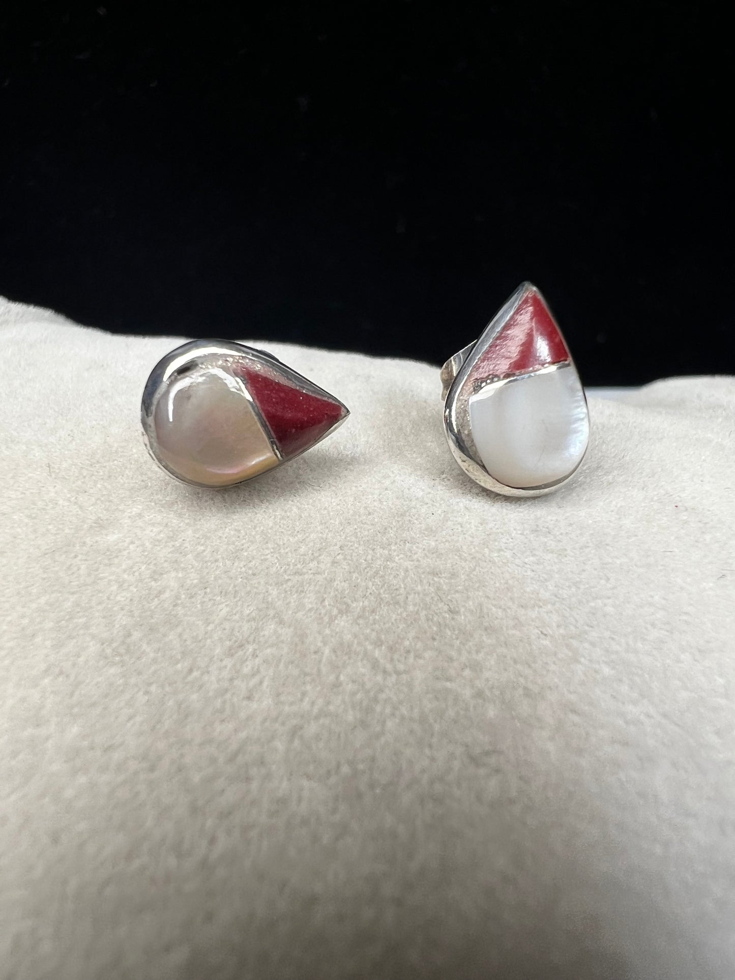These small vintage sterling silver earrings feature delicate mother of pearl inlays accented with a splash of color. Their classic design adds a vintage-inspired touch that complements both casual and formal ensembles with subtle sophistication.