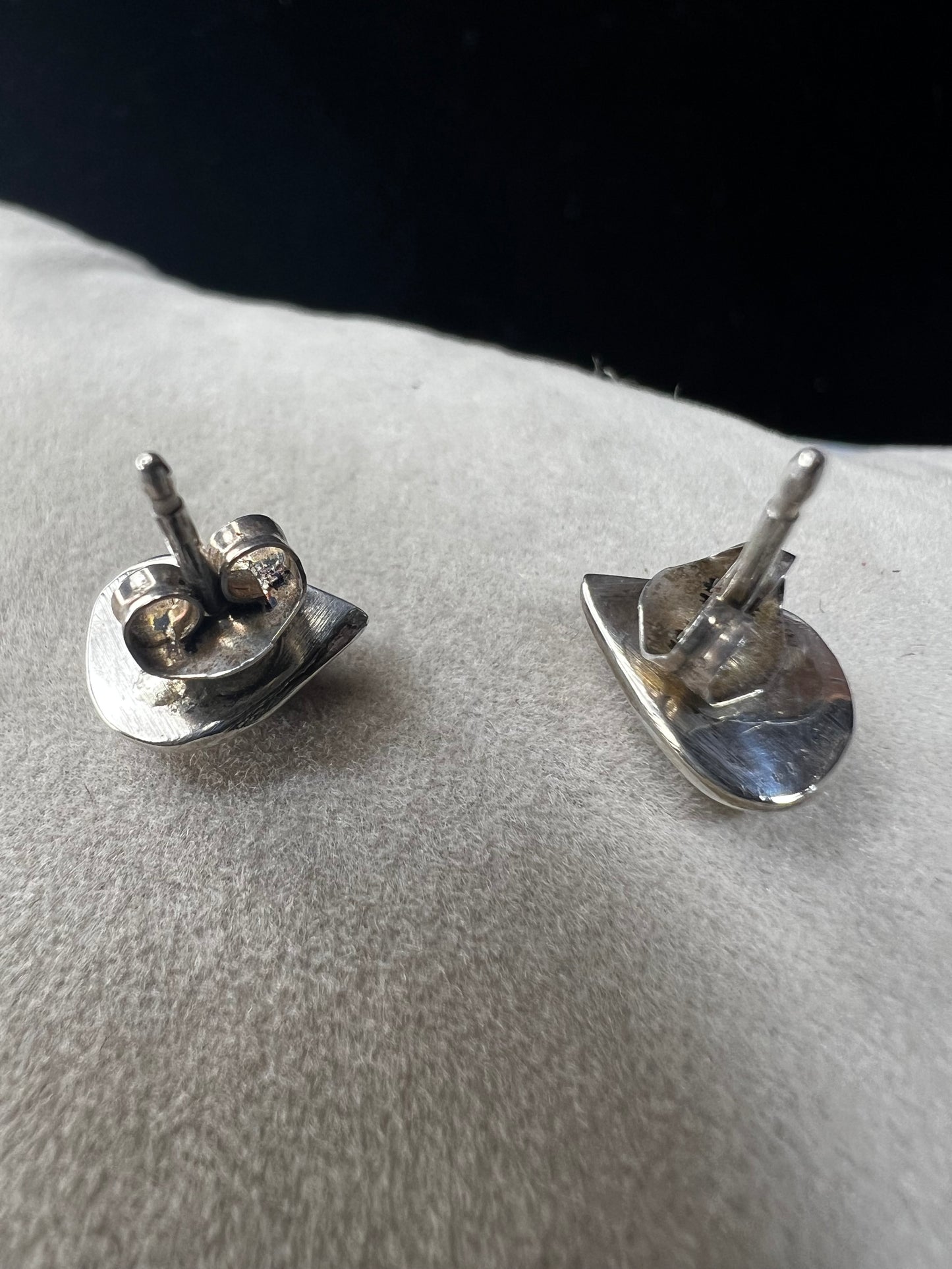 These small vintage sterling silver earrings feature delicate mother of pearl inlays accented with a splash of color. Their classic design adds a vintage-inspired touch that complements both casual and formal ensembles with subtle sophistication.