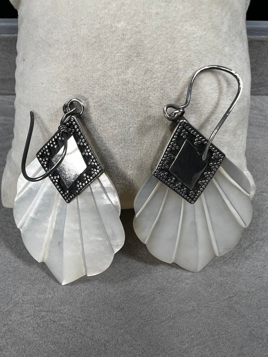 Crafted from sterling silver and mother of pearl, these vintage earrings measure about 3 inches long, making a bold and elegant statement.