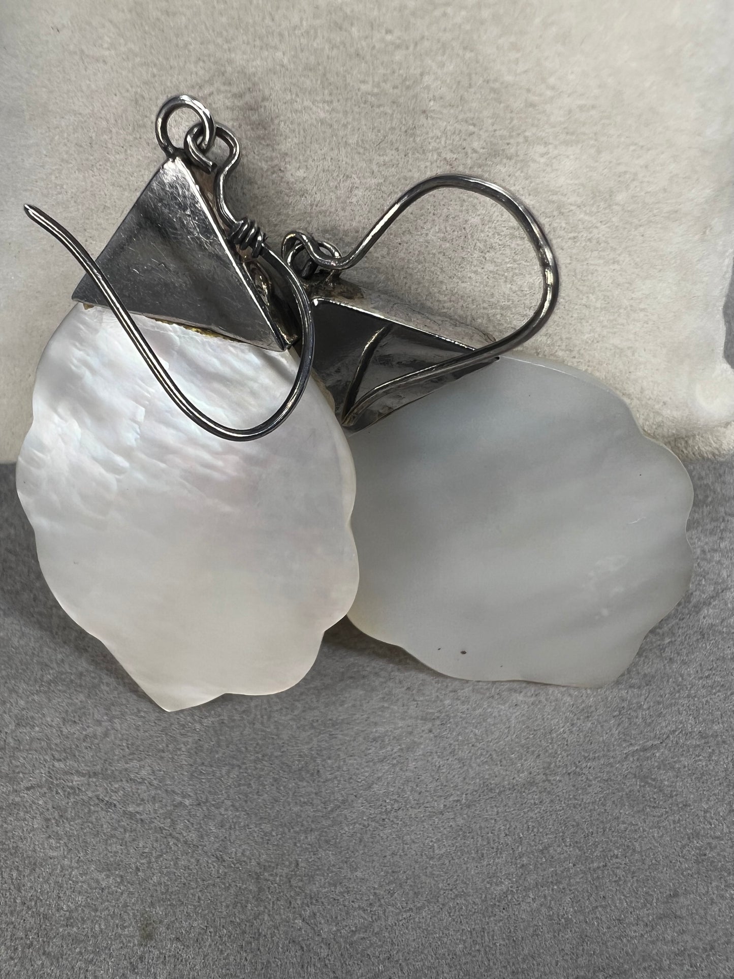Crafted from sterling silver and mother of pearl, these vintage earrings measure about 3 inches long, making a bold and elegant statement.