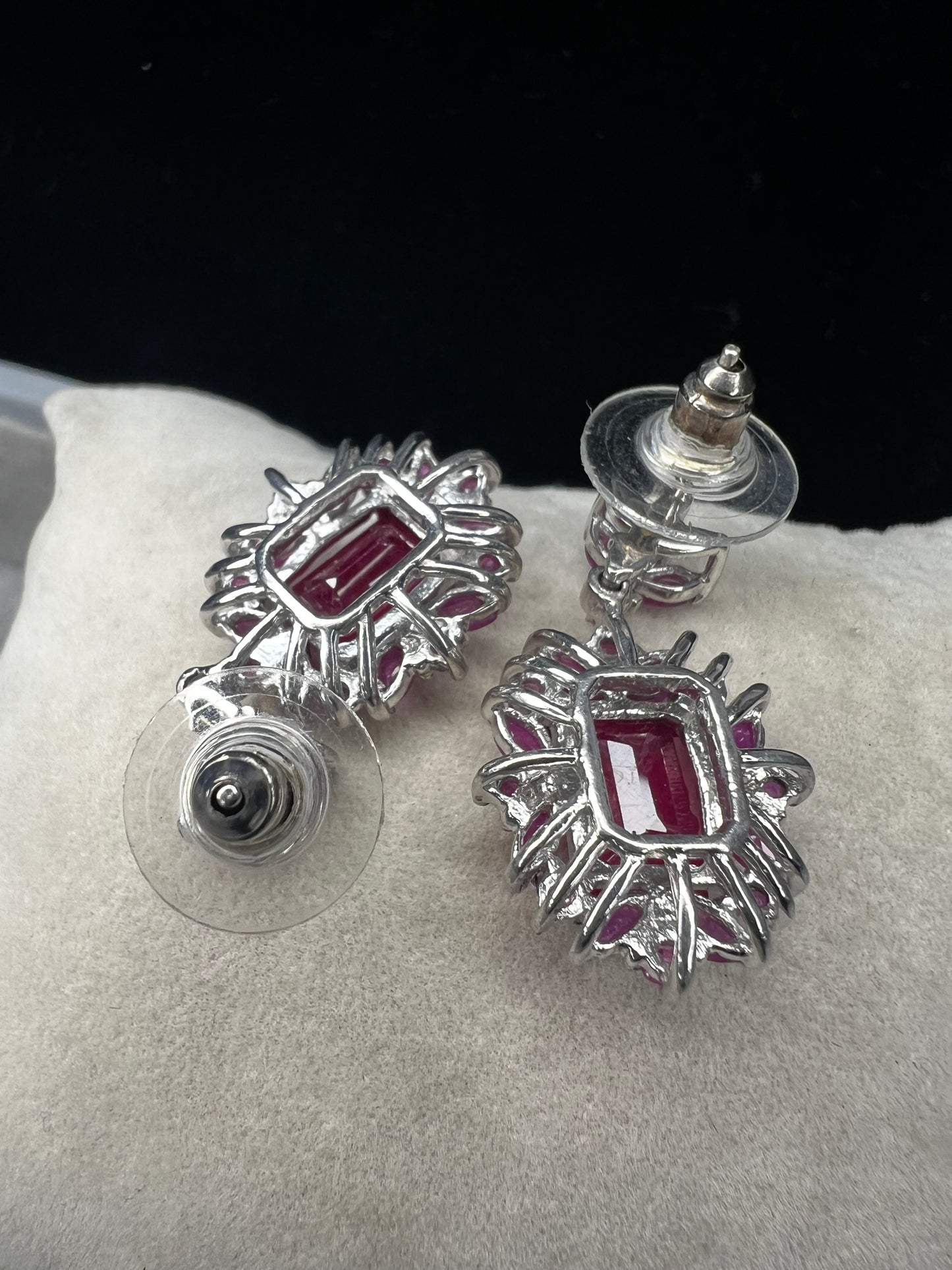 These sterling silver earrings feature a striking large ruby centerpiece, elegantly framed by sparkling topaz stones. Crafted with lab-created gems, they offer a luxurious look at a more accessible price point.