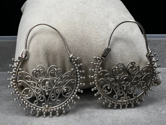 These sterling silver earrings offer a distinctive design that balances boldness with subtlety. Their intricate detailing adds sophistication without overwhelming your look.