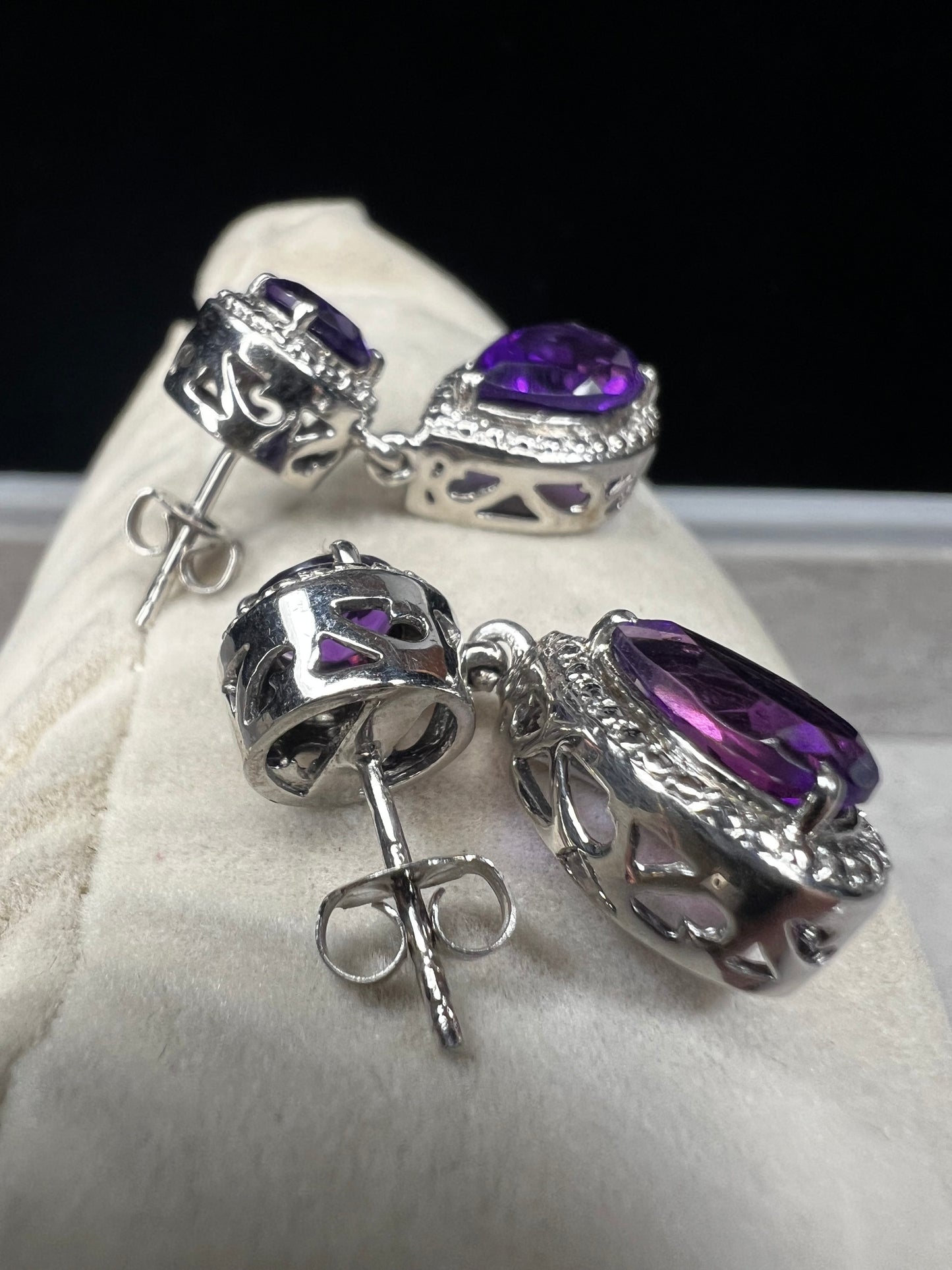 These sterling silver and amethyst drop earrings combine elegant design with quality craftsmanship. Perfect for adding a subtle pop of color to any outfit.v