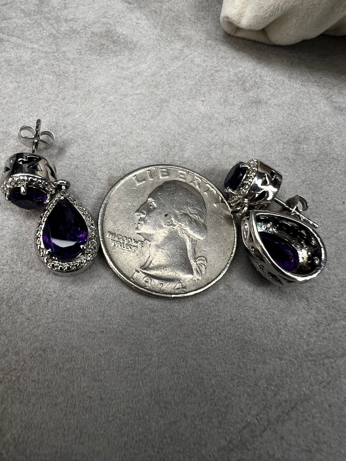 These sterling silver and amethyst drop earrings combine elegant design with quality craftsmanship. Perfect for adding a subtle pop of color to any outfit.