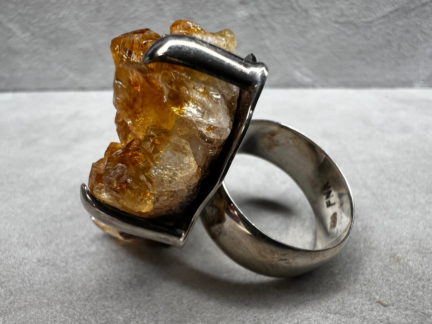This sterling silver ring showcases a striking citrine specimen, expertly set to highlight its natural beauty. The warm, golden hues of the citrine contrast elegantly with the polished silver band, creating a sophisticated piece that commands attention.