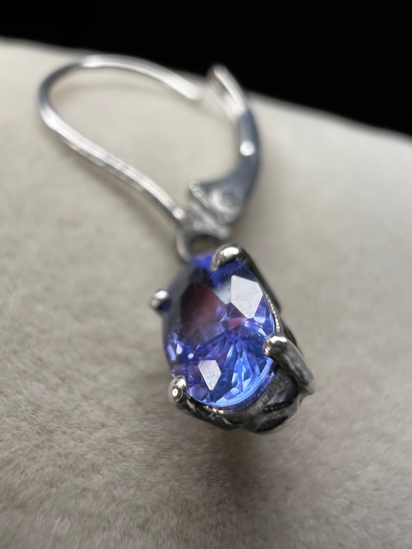 These sterling silver drop earrings feature a delicate tanzanite gemstone, adding a subtle splash of color and graceful movement to your look. Ideal for everyday wear or special occasions.