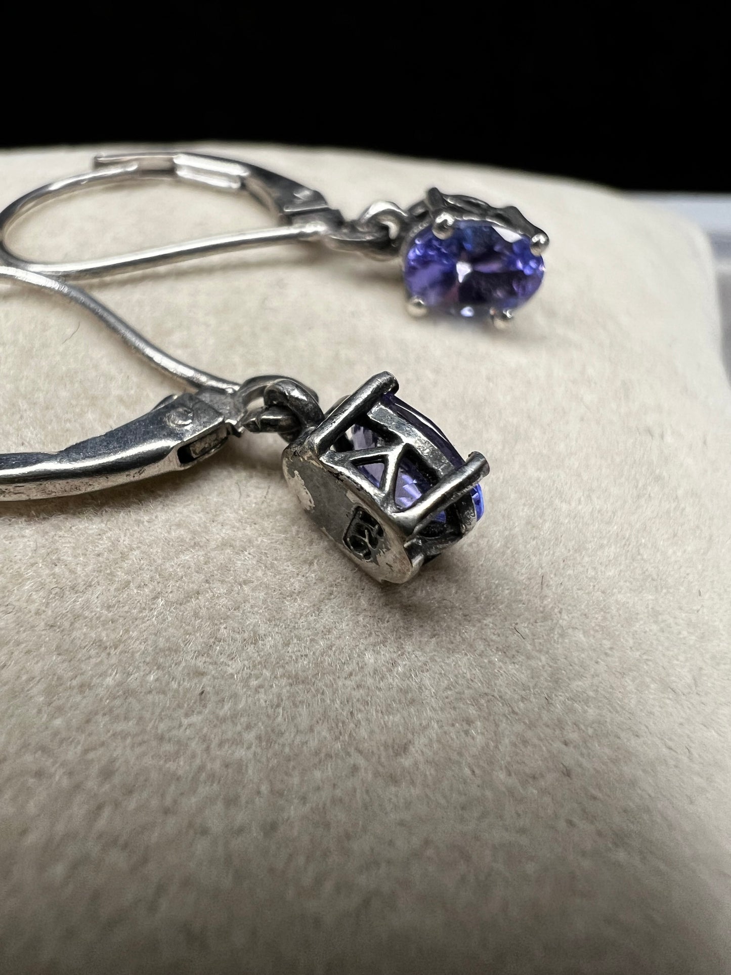 These sterling silver drop earrings feature a delicate tanzanite gemstone, adding a subtle splash of color and graceful movement to your look. Ideal for everyday wear or special occasions.