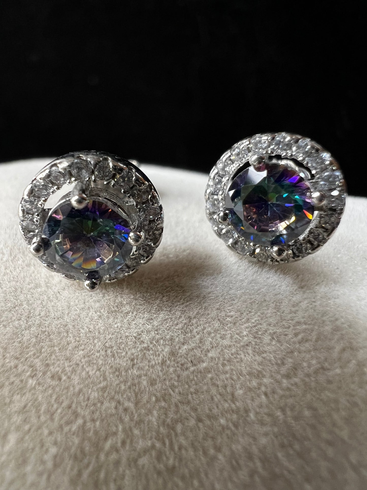 Accented with a halo of sparkling cubic zirconia, these sterling silver earrings frame their mystic quartz centers with brilliant light-catching detail.