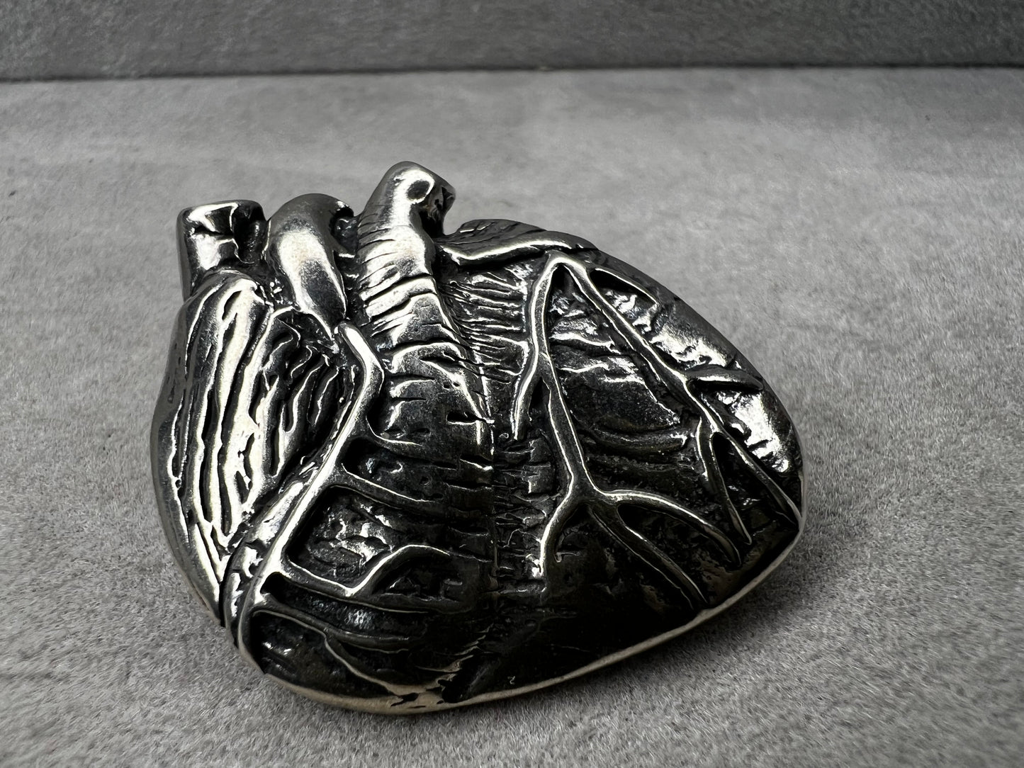This sterling silver brooch, titled "Collision of Ideas," is expertly crafted to resemble a human heart. Its unique design combines artistic expression with fine craftsmanship.