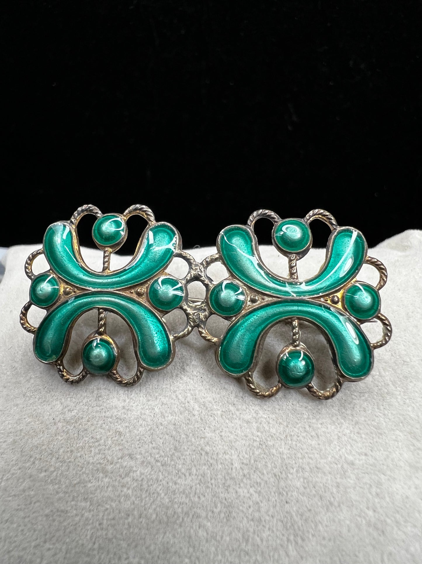 This antique sterling silver brooch features a unique candy green enamel that captures attention with its vibrant charm. A distinctive piece from the turn of the 20th century, it offers a one-of-a-kind style that sets you apart in any room.