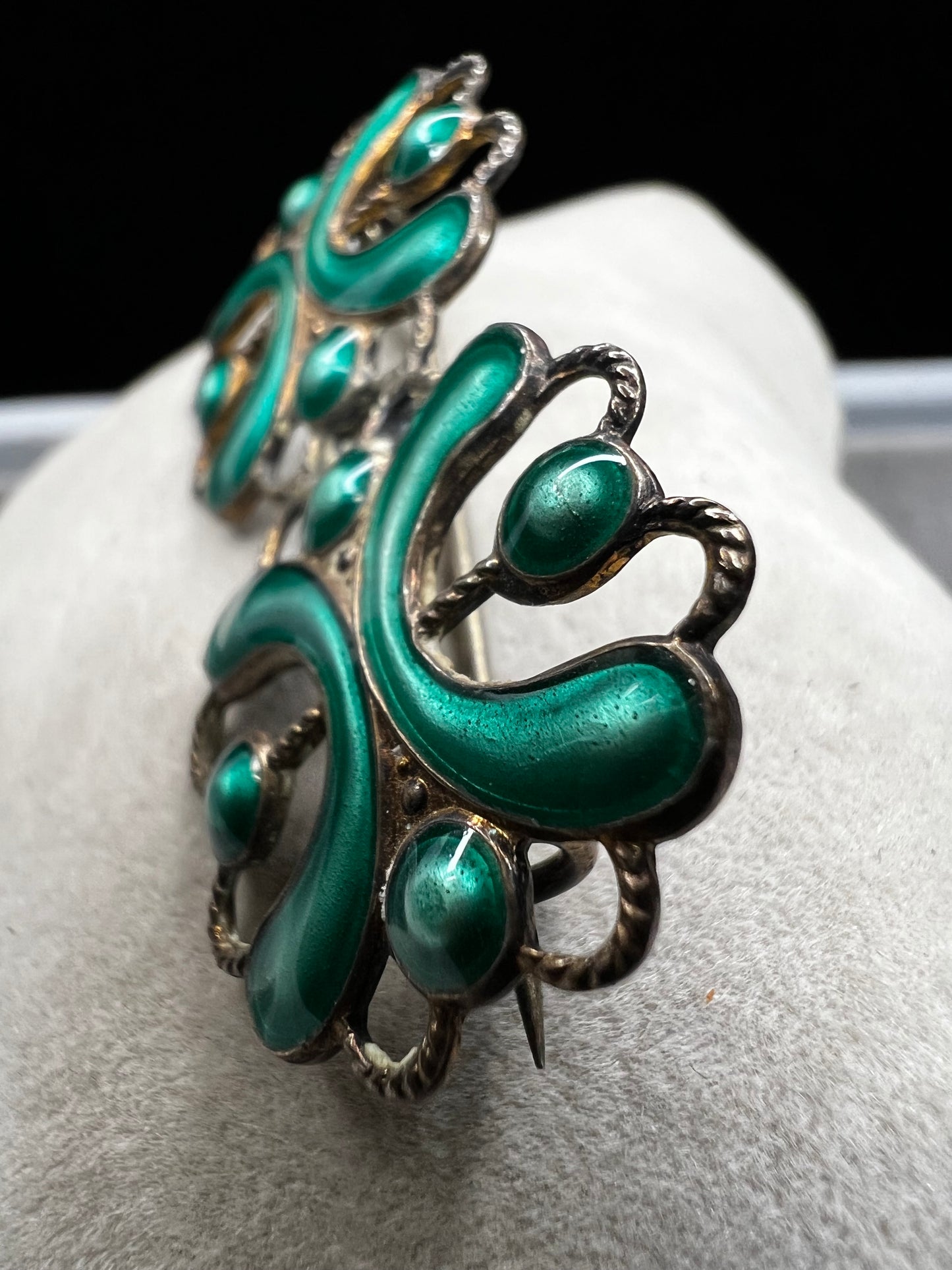 This antique sterling silver brooch features a unique candy green enamel that captures attention with its vibrant charm. A distinctive piece from the turn of the 20th century, it offers a one-of-a-kind style that sets you apart in any room.